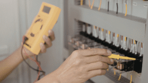 Engenheiro realizando medição em painel elétrico para projeto de eficiência energética industrial e redução de custos.