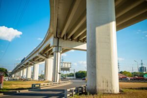 Estrutura de pilares de concreto de um viaduto logístico, representando as Obras de Arte Especiais (OAEs) sujeitas à fadiga estrutural.